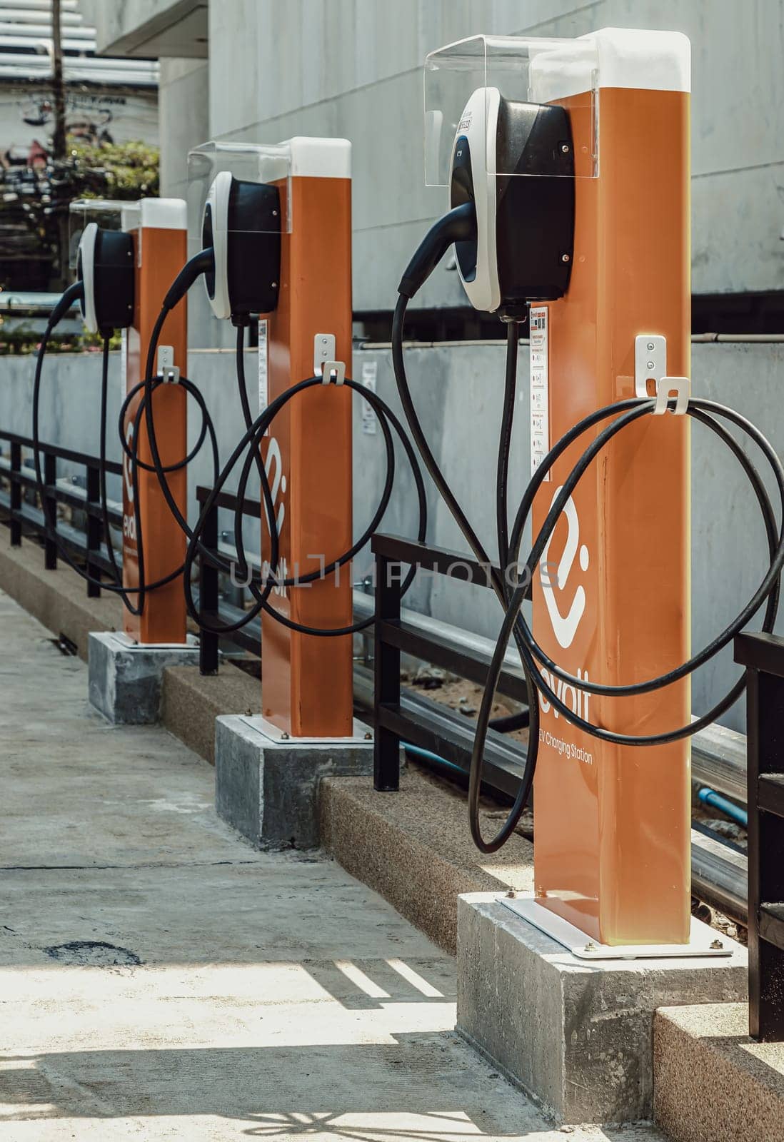 Bangkok, Thailand - Feb 18, 2023 : A Row of The Evolt electric car charging point at a car park. Electric Vehicle Charging Station in a commercial parking lot, Space for text, Selective focus.