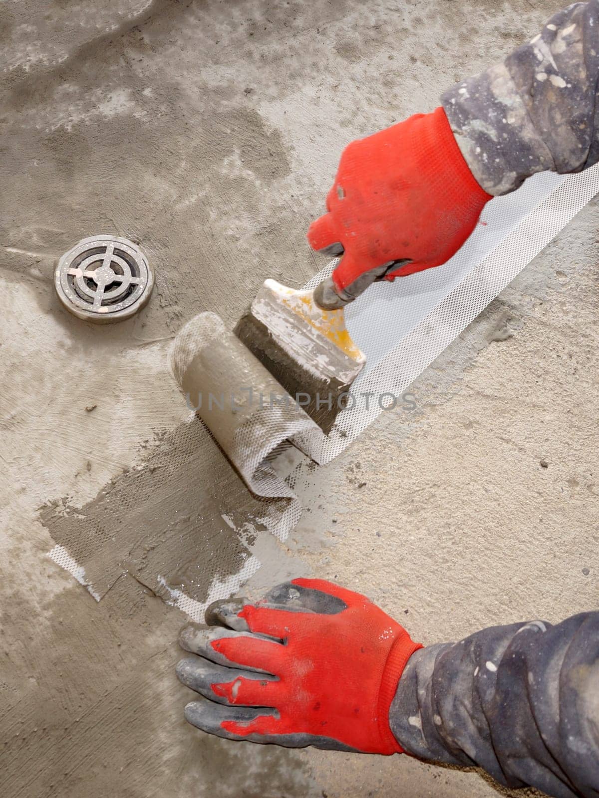 waterproofing the floor in a wet room, applying the solution to the waterproofing tape close-up