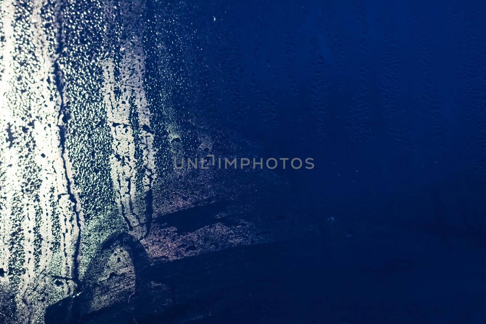 Raindrops and stains on glass at night in the city, background