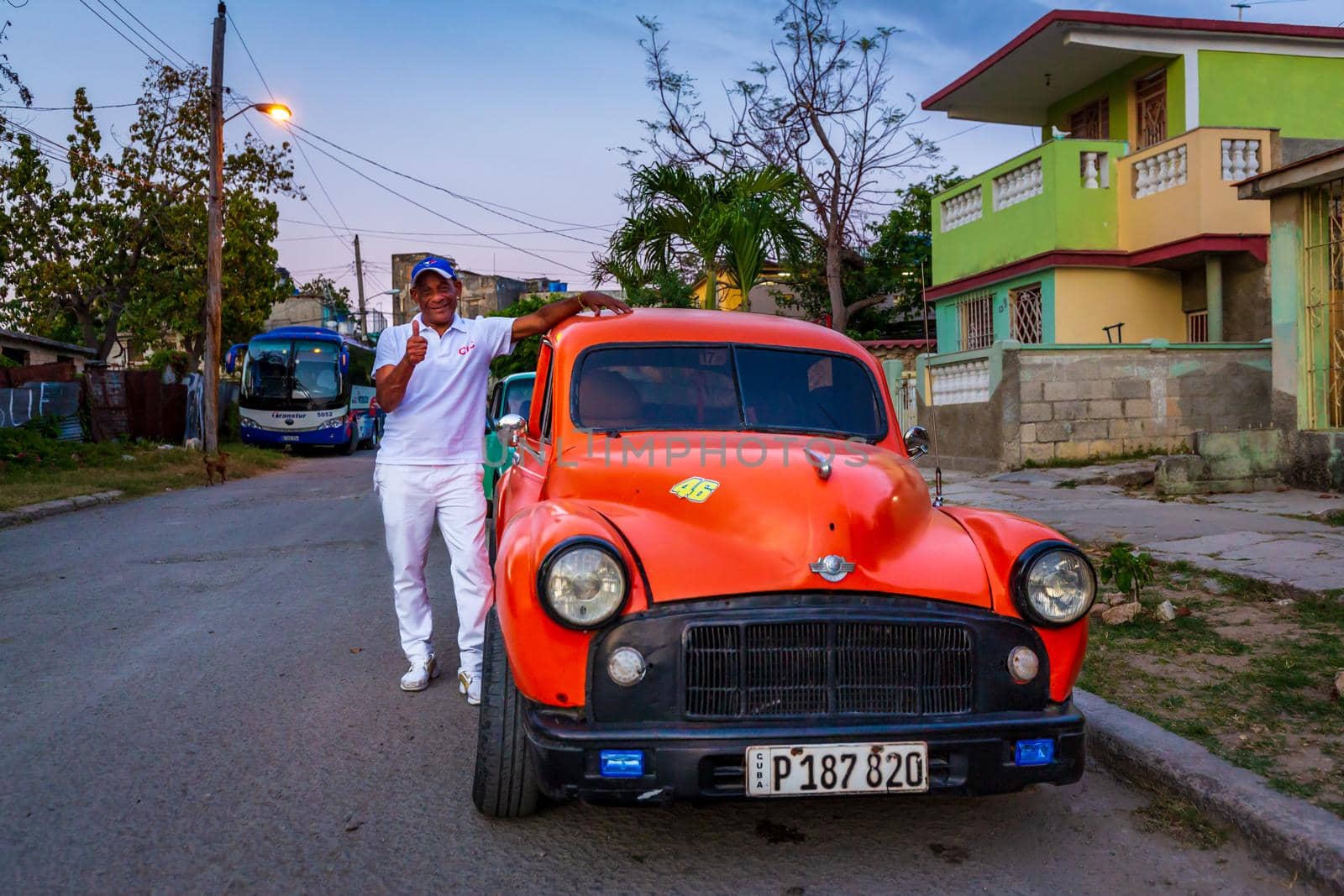 Havana, Cuba - March 12, 2020: A classic American car parked in the street of Havana, Cuba, with its owner standing by the side.