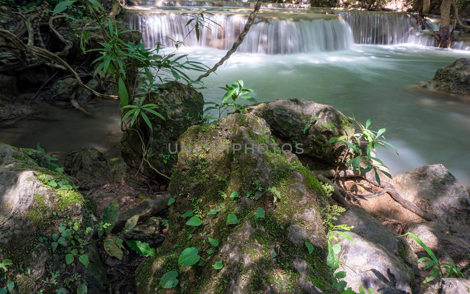 The clean waterfall there is an emerald green colour caused by reflections from trees and lichen circulating through the yellow limestone. Huai Mae Khamin Waterfall, Kanchanaburi Province