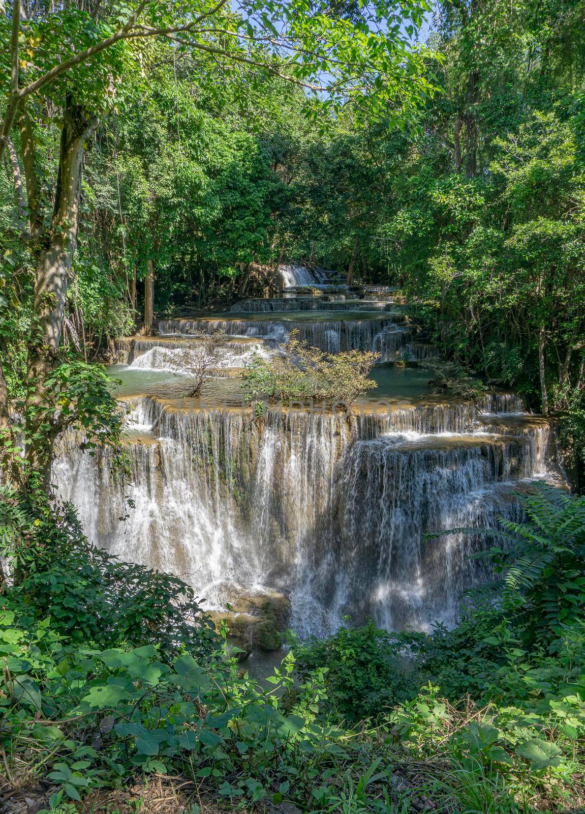 Many waterfalls flow in the frame of plants and green trees. Huai Mae Kamin Waterfall Viewpoint, Kanchanaburi Province