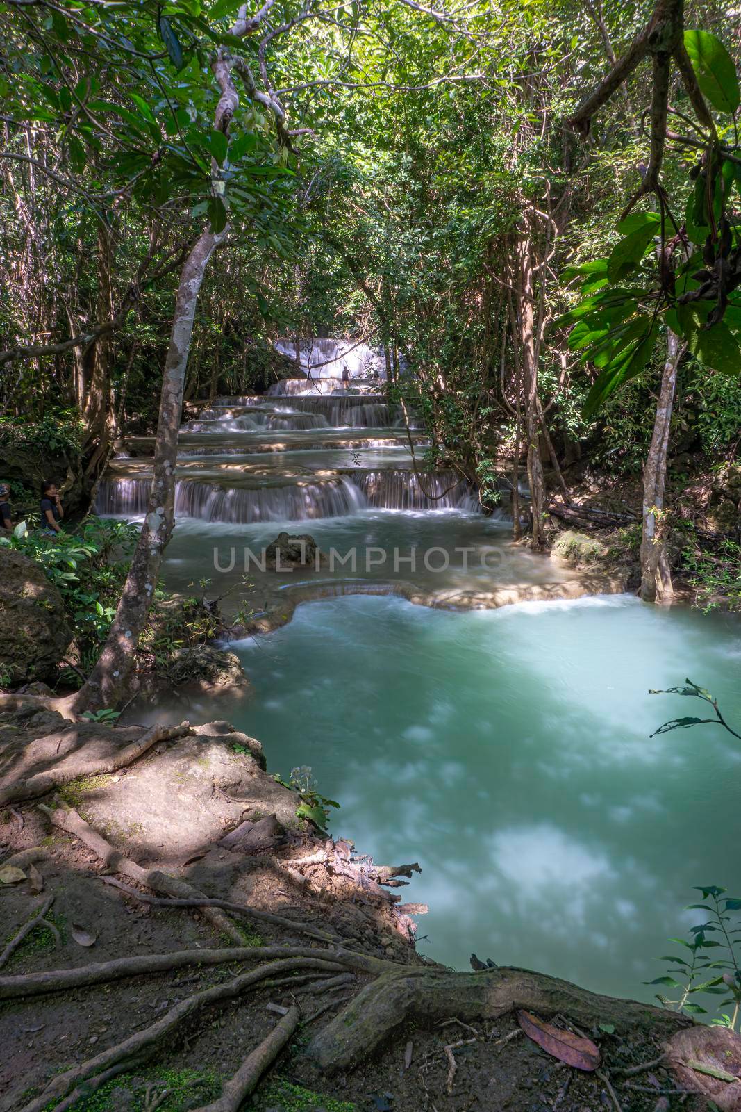 The clean waterfall there is an emerald green colour caused by reflections from trees and lichen circulating through the yellow limestone. Huai Mae Khamin Waterfall, Kanchanaburi Province