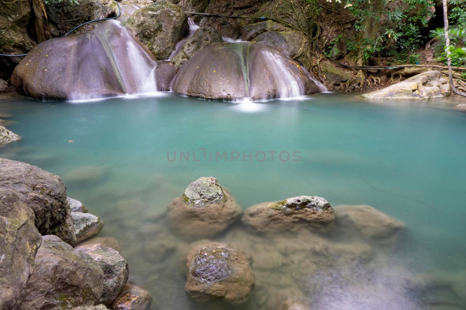 Clean green emerald water from the waterfall Surrounded by small trees - large trees,  green colour, Erawan waterfall, Kanchanaburi province, Thailand