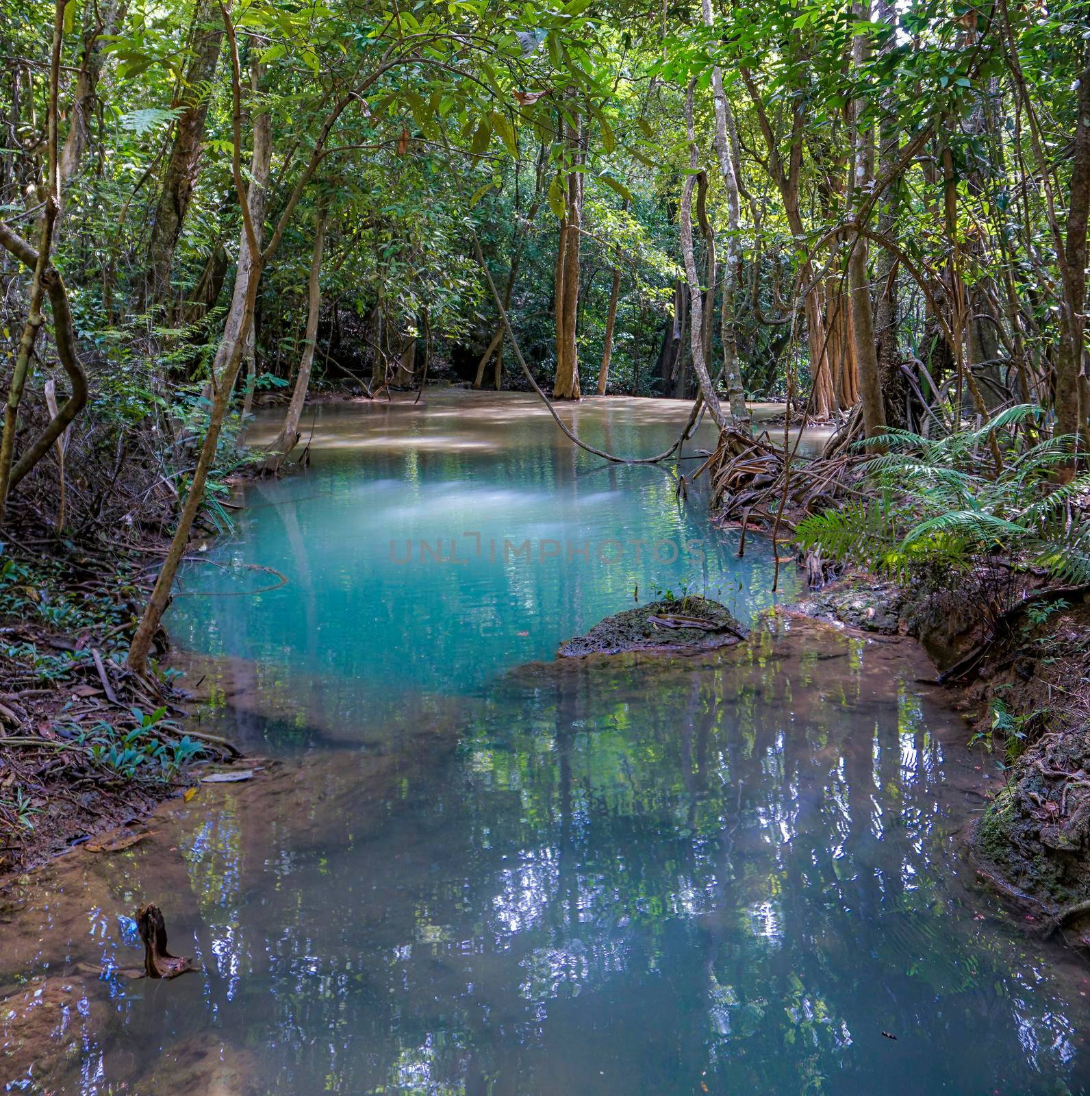 The clean waterfall there is an emerald green colour caused by reflections from trees and lichen circulating through the yellow limestone. Huai Mae Khamin Waterfall, Kanchanaburi Province