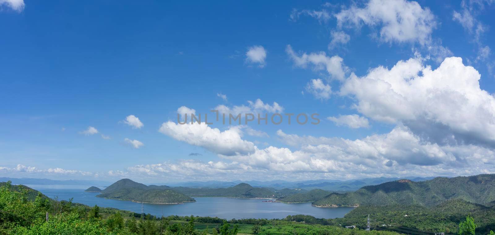 Clear blue sky white clouds, trees, natural grass trees around the Srinakarin Reservoir, Kanchanaburi, Thailand