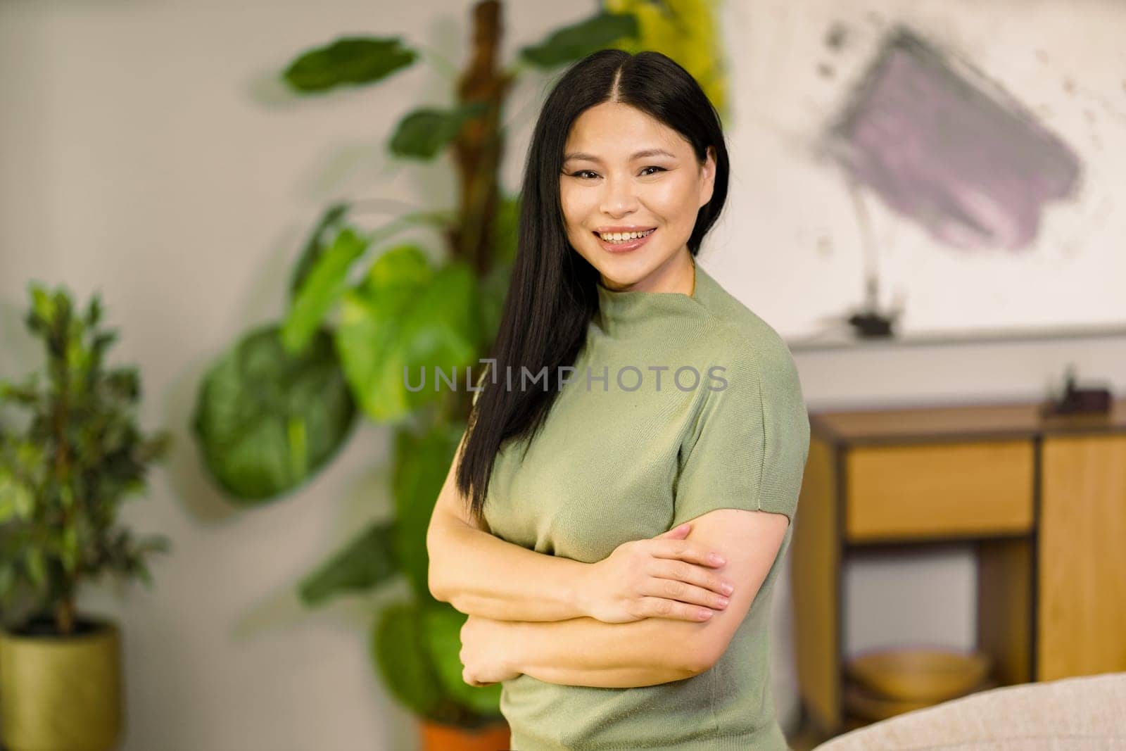 Middle-aged woman smiles with vibrant energy at home, embodying the concepts of healthy lifestyle and biohacking, promoting wellness and self-care. High quality photo