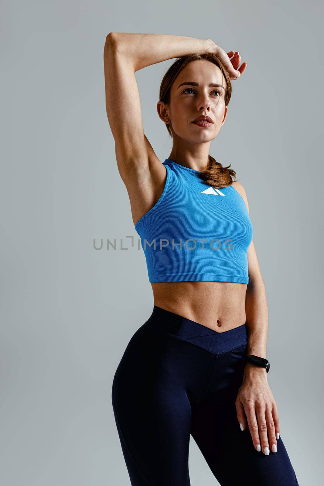 Fitness woman wearing sportswear posing over studio background. High quality photo