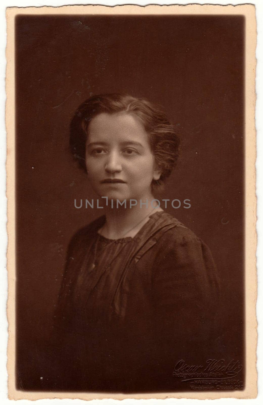 Vintage photo shows woman - portrait. Retro black and white studio photography with sepia effect. Circa 1920s by roman_nerud