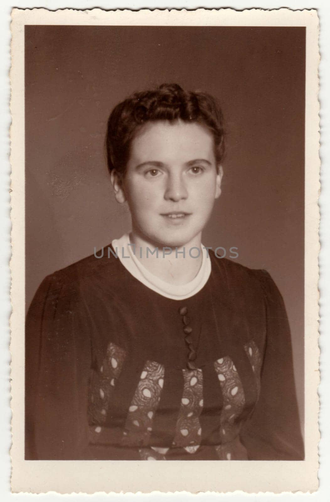 Vintage photo shows woman with short hair. Retro black and white studio photography with sepia effect. Circa 1950s. by roman_nerud