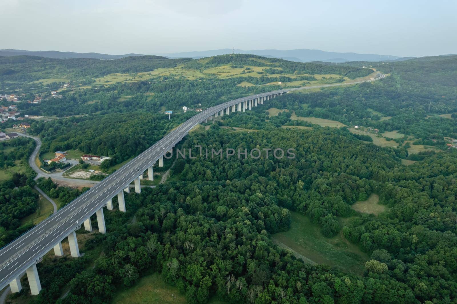 Transport bridge in mountainous area, road and trees. A panoramic view of nature from above.