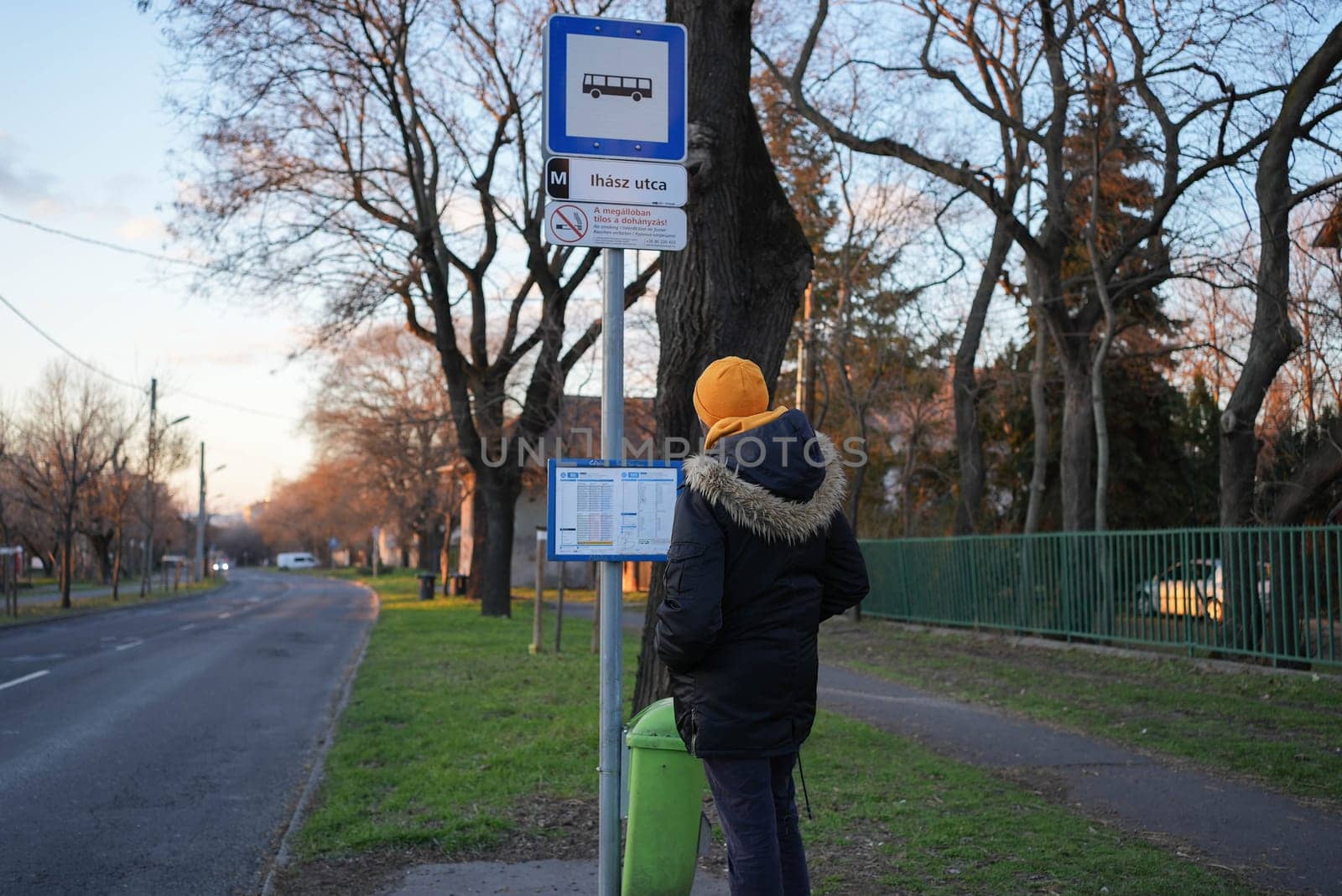 Guy looking at the bus schedule at a suburban area. High quality photo