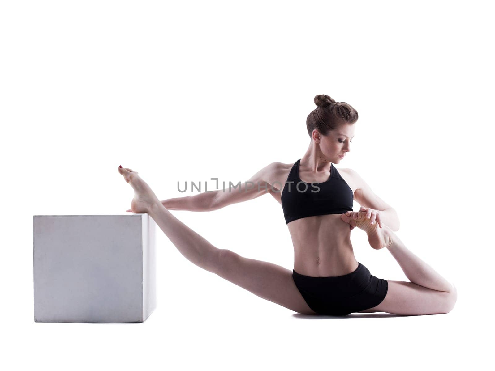 Beautiful girl doing stretching in studio, isolated on white