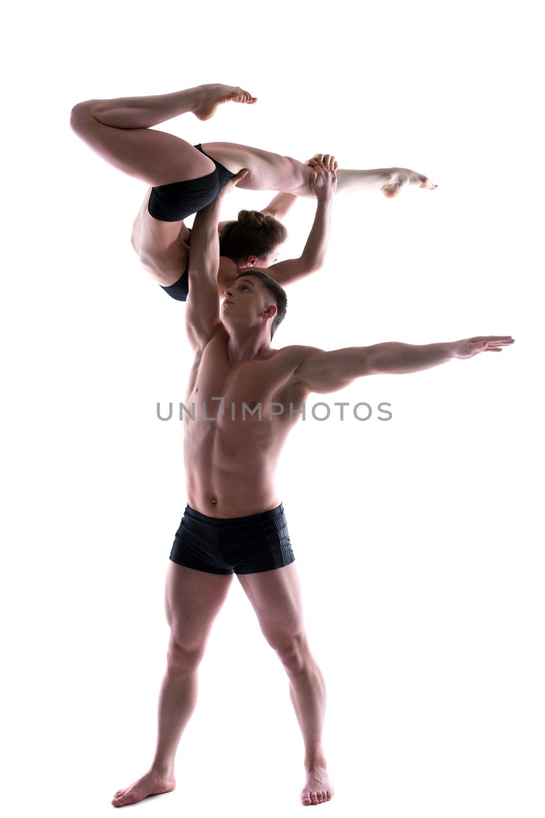 Couple of young graceful acrobats posing in studio, isolated on white