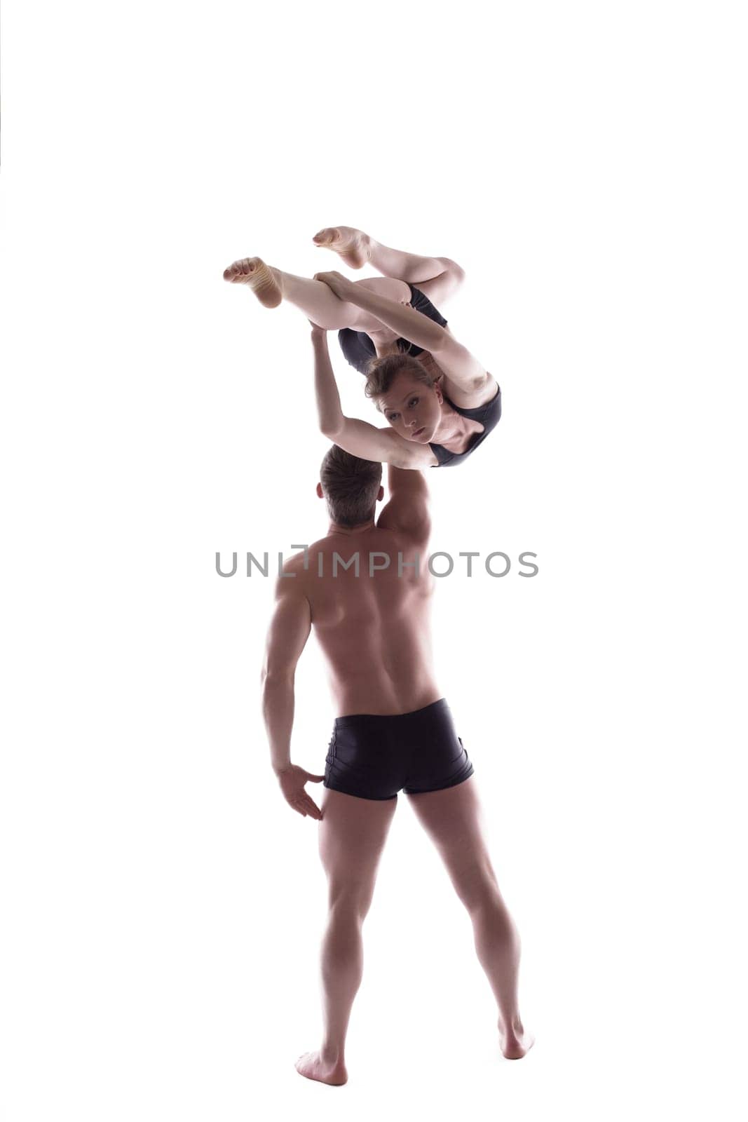 Young athletic people carry out acrobatic tricks, isolated on white