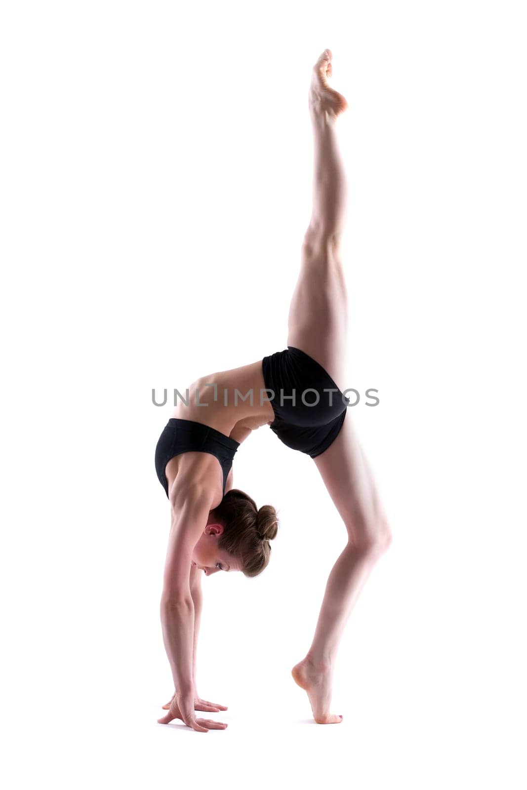 Young flexible brunette posing in studio, isolated on white