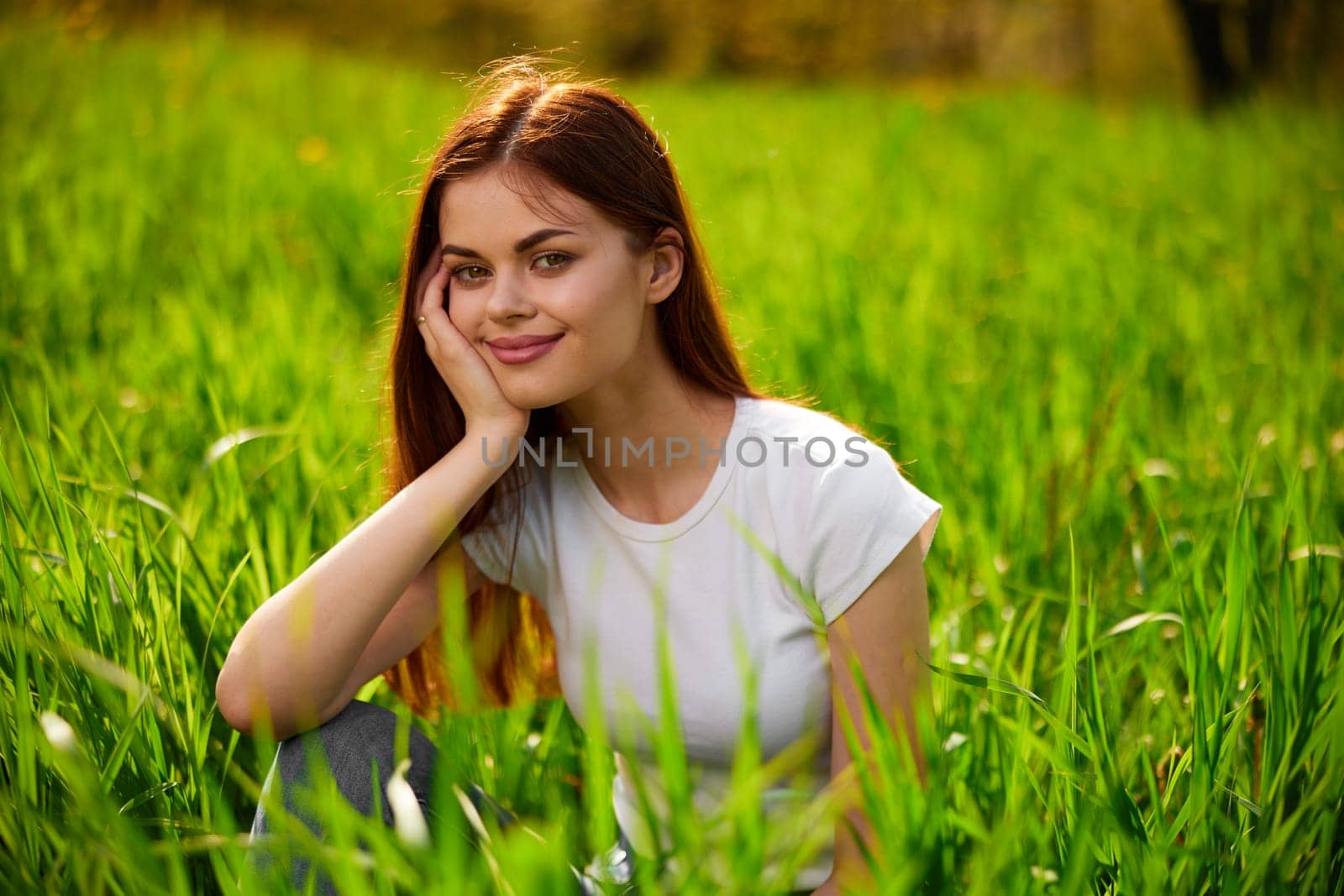 Beautiful young woman close up portrait among green cereal grass. High quality photo