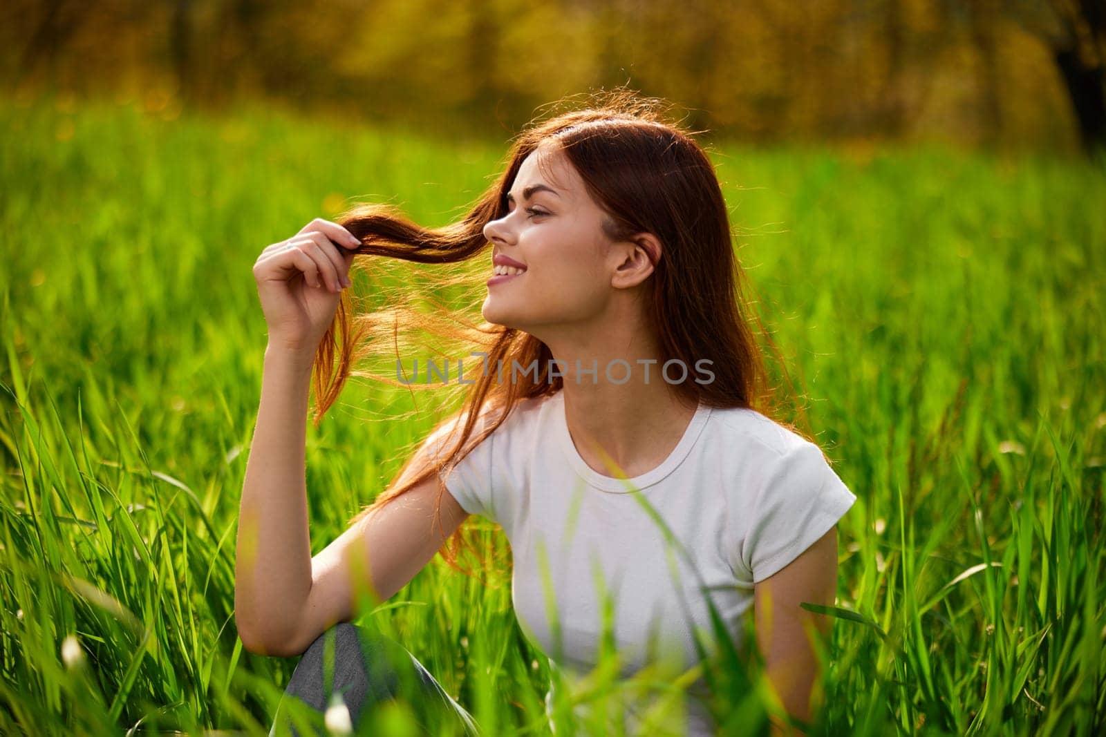 Beautiful young woman close up portrait among green cereal grass. High quality photo