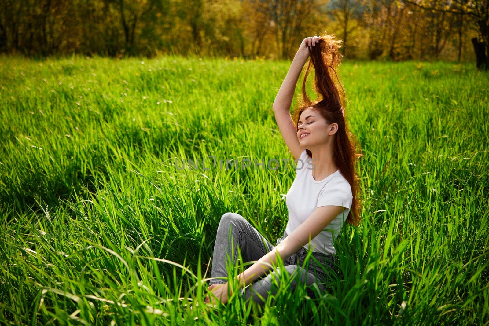 Happy young woman relaxing on a beautiful summer field. by Vichizh