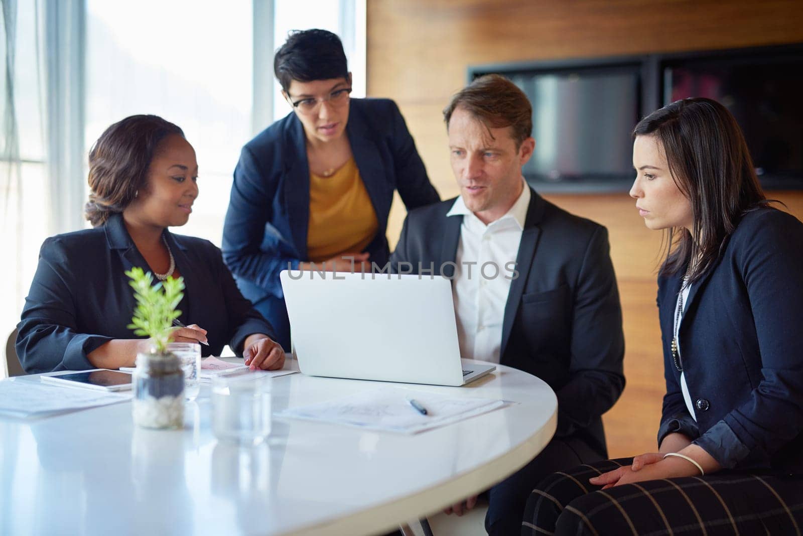 Showing off his work. four corporate businesspeople working in the boardroom. by YuriArcurs