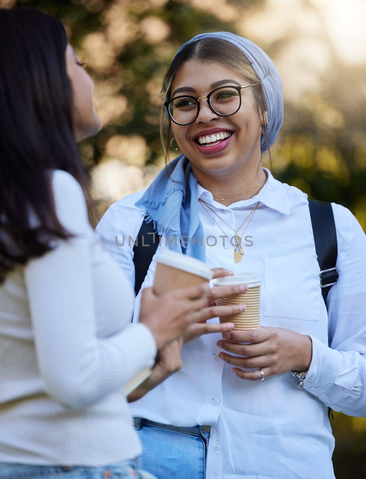 Happy, break or students talking at park on university campus for learning, education or goals together. Girls talk, Islamic or students relaxing with coffee meeting for research or college knowledge.