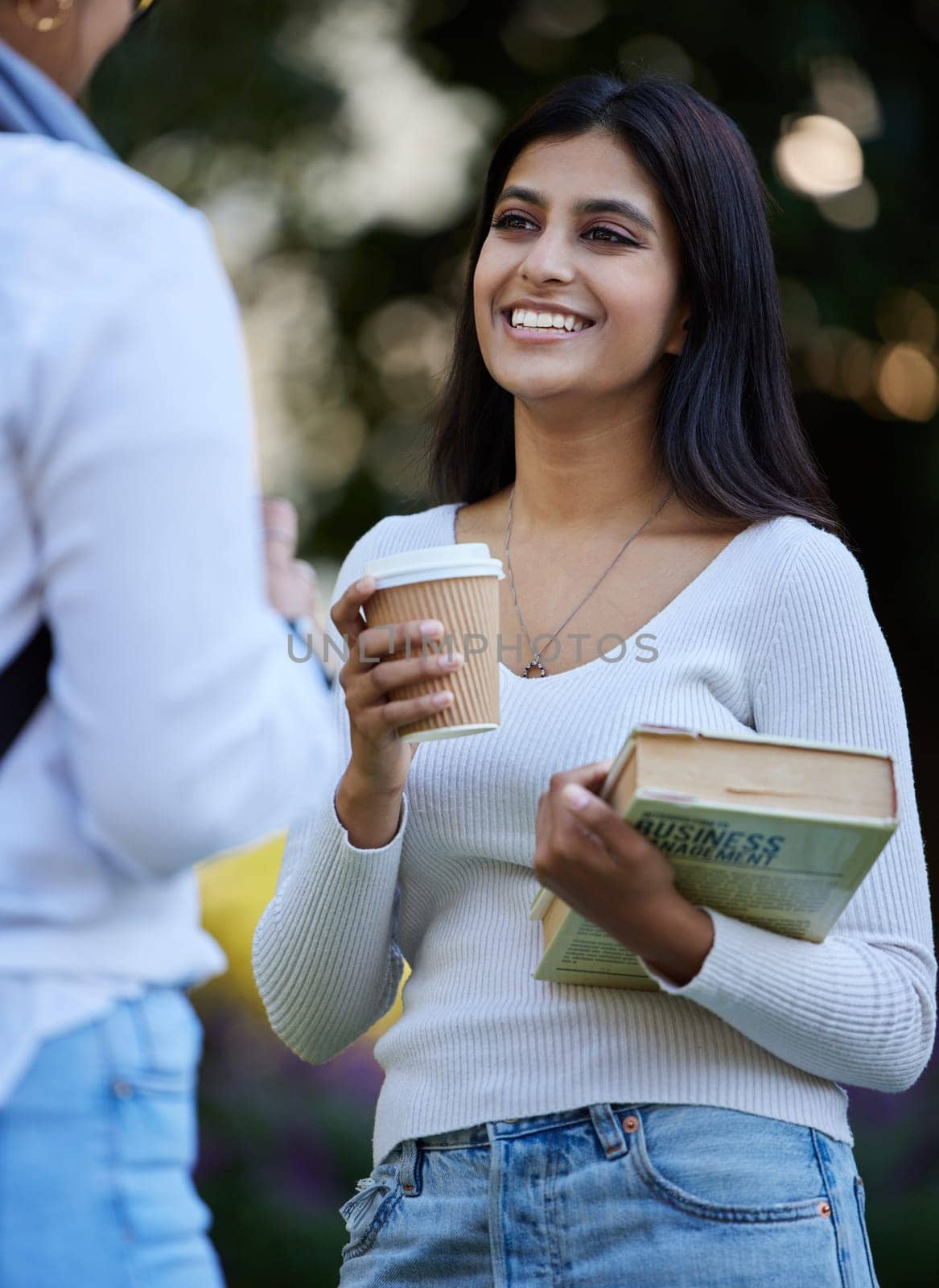 Smile, break or students talking at park on university campus for learning, education or books together. Girls talking, happy or students relax with coffee meeting for research or college knowledge.