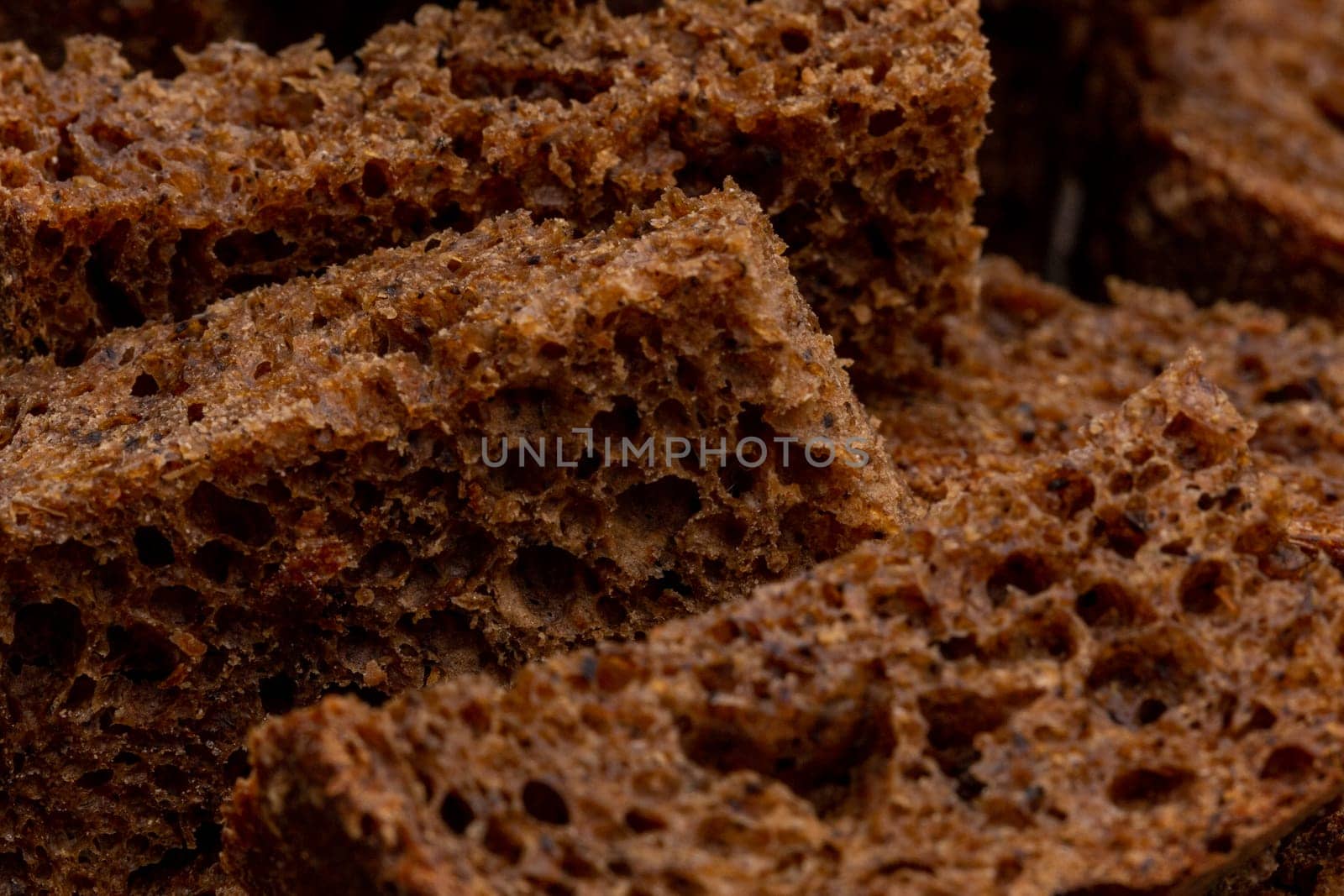 Rye croutons close-up view, dark bread texture, macro photography
