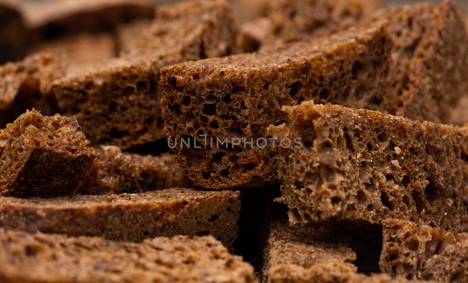 Rye croutons close-up view, dark bread texture, macro photography