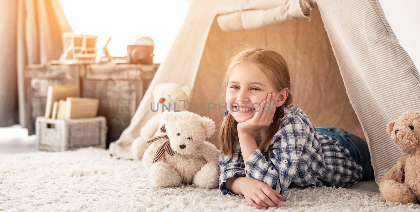 Little girl lying in wigwam with teddies by GekaSkr