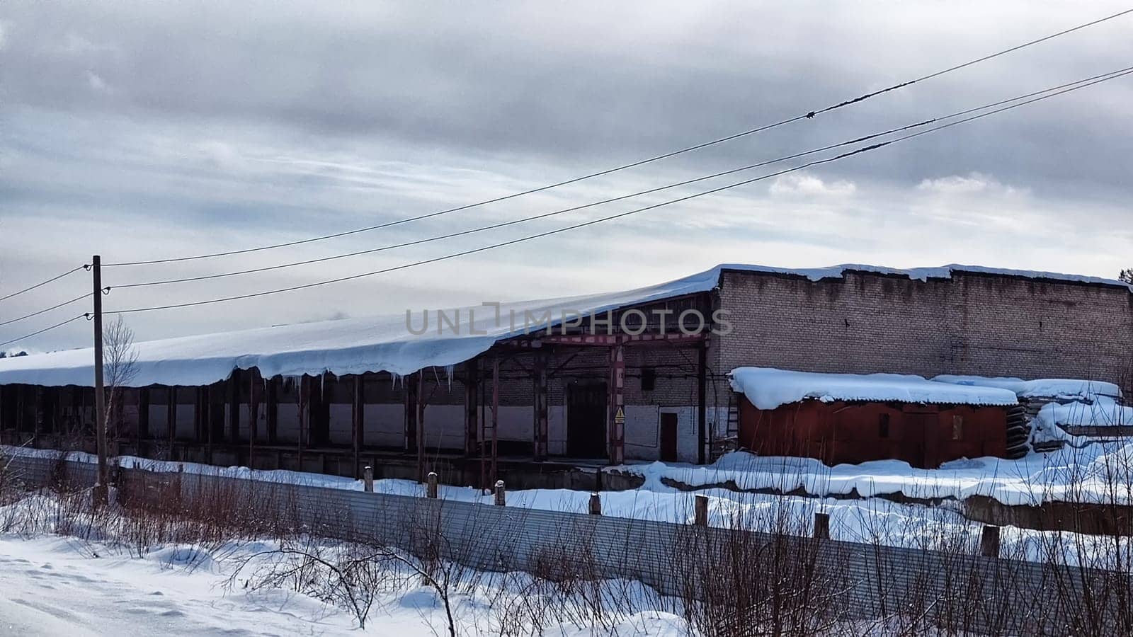 Abandoned Industrial Buildings in winter day and sky with white clouds on the Background
