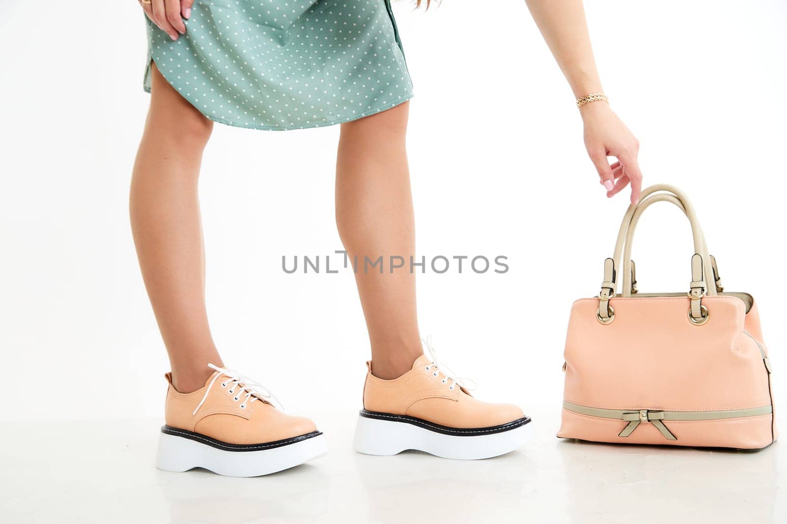 Beautiful sneakers on woman legs in studio on white background. Fashionable shooting of a young girl with beautiful legs