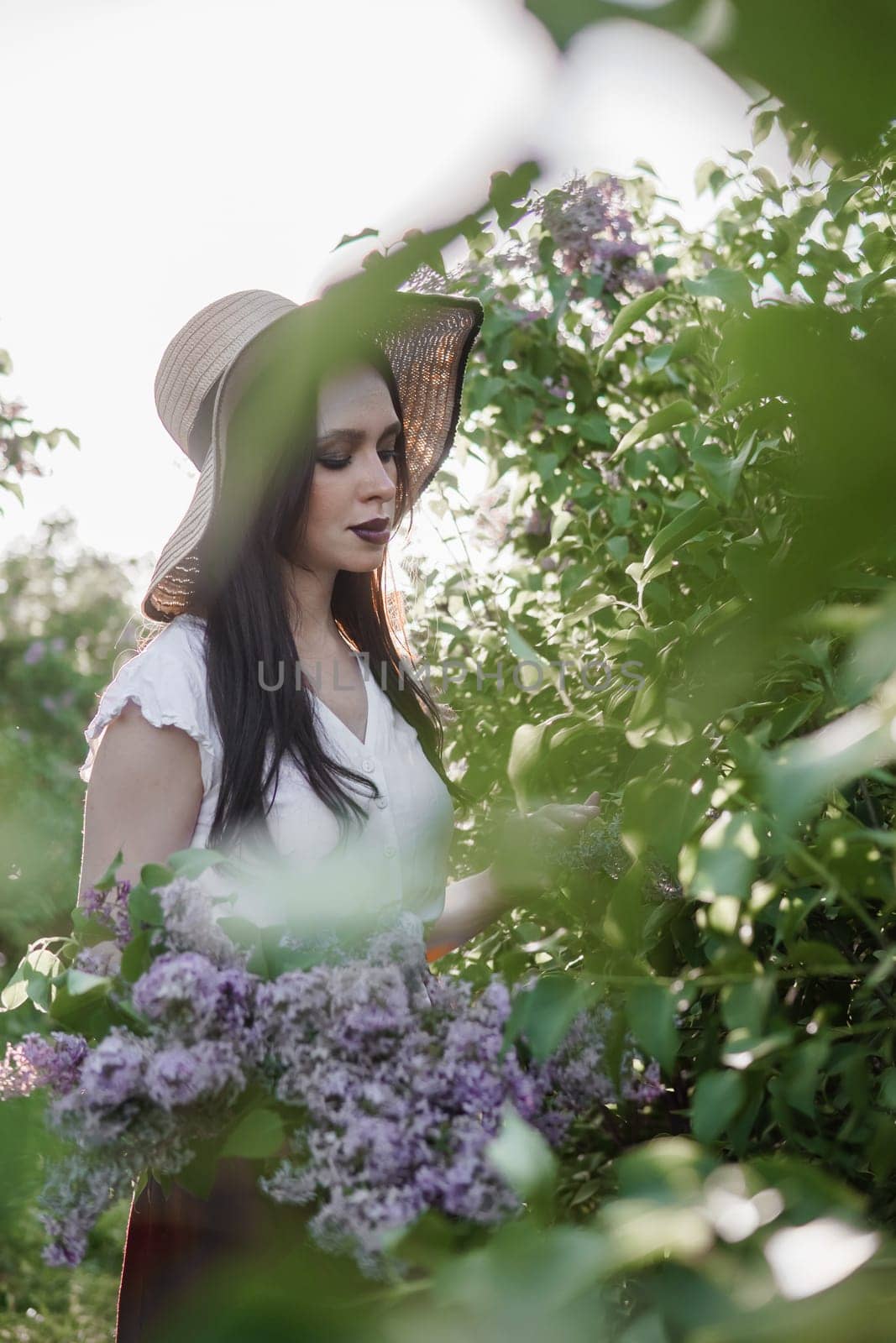 A fashionable girl with dark hair, a spring portrait in lilac tones in summer. Bright professional makeup