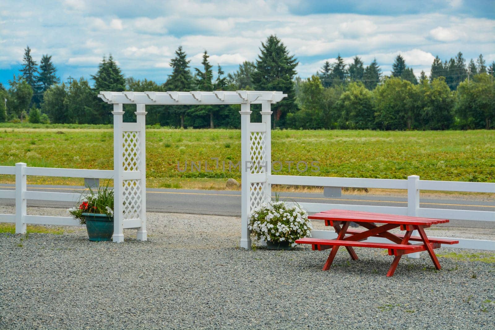 Flowers and red table at the entrance to produce farm store.