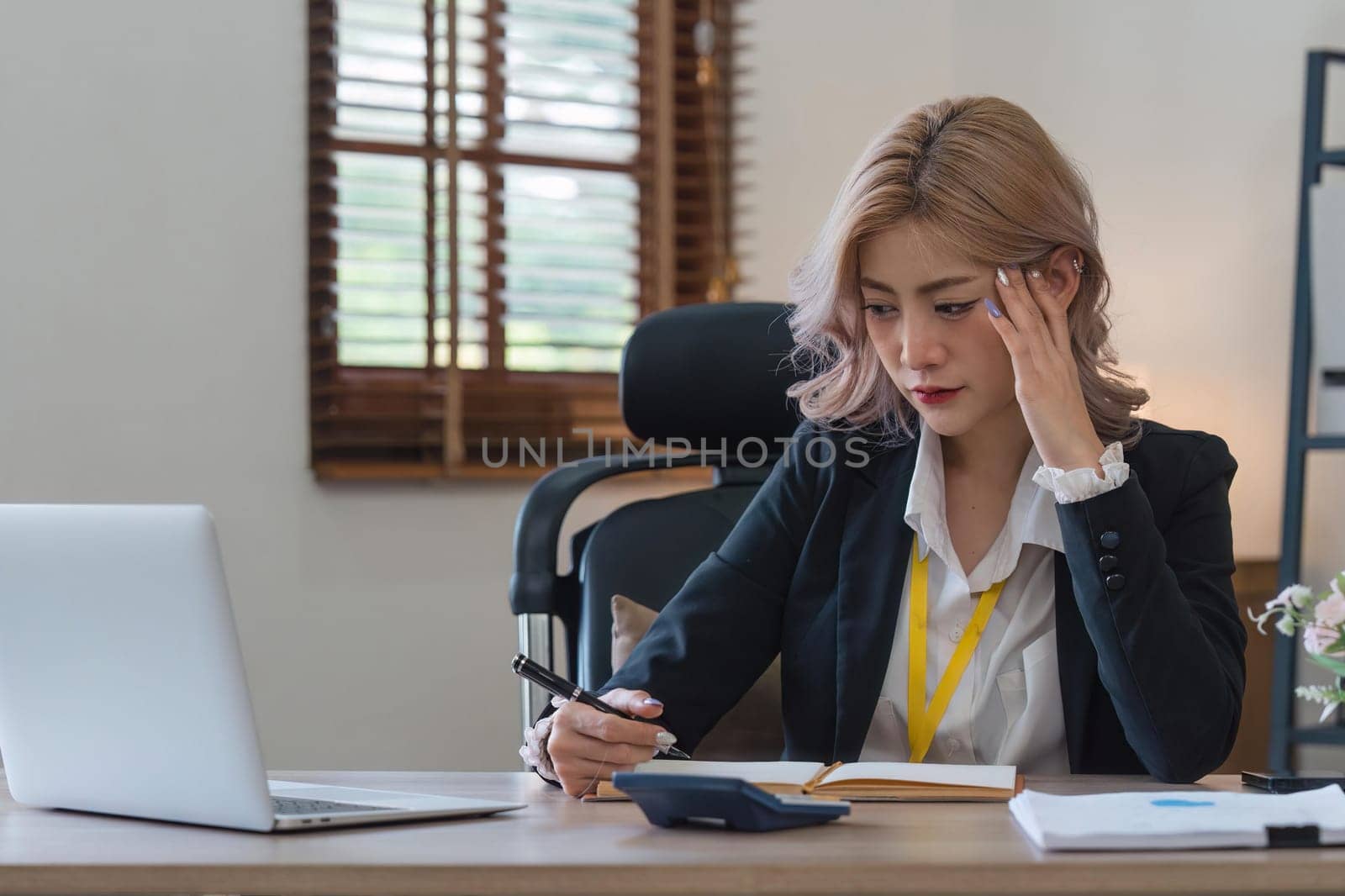 Businesswoman tired and stressed with overworked at desk, woman asian with worried not idea with graph analysis laptop and at office.