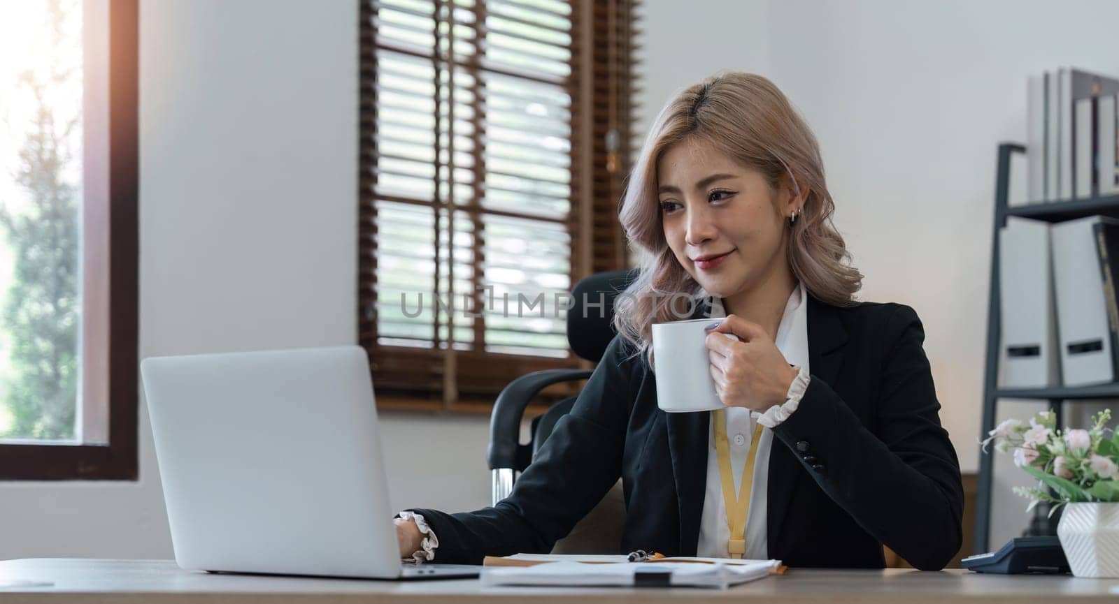Asian woman business using a calculator calculating financial expense at home office.