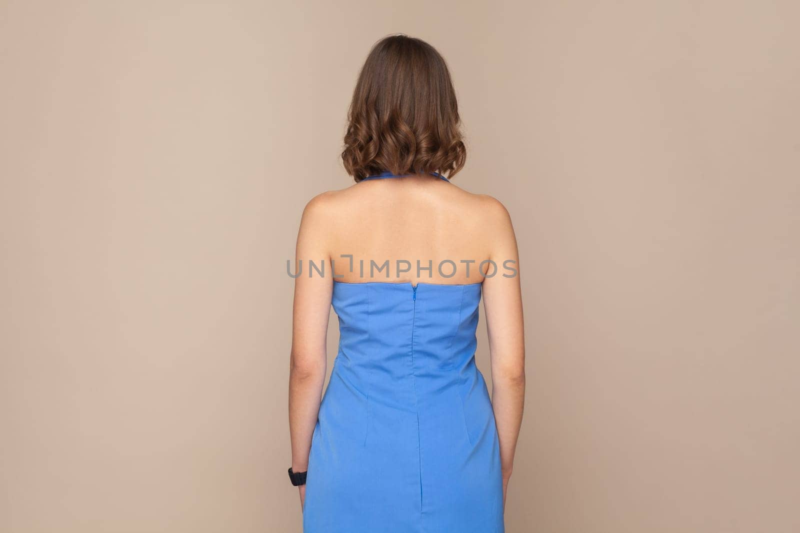 Unknown woman standing backwards to camera with bare shoulders, wearing elegant blue dress. by Khosro1