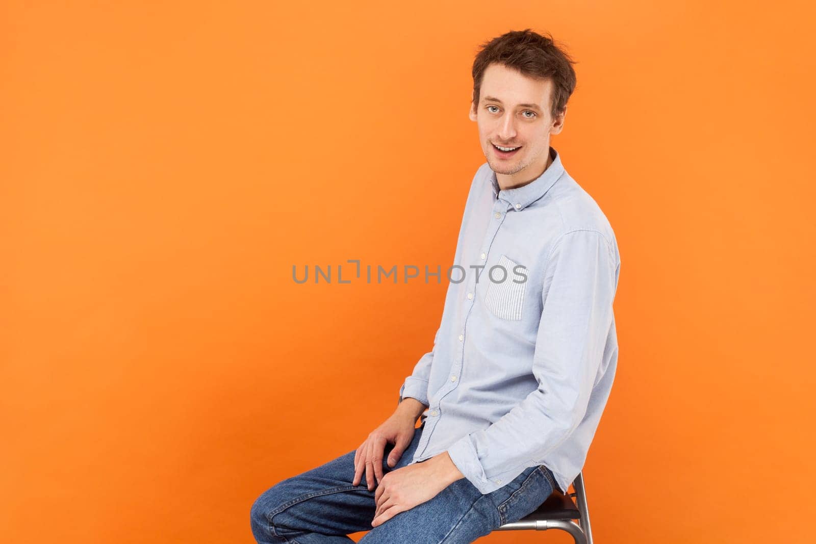 Handsome attractive man sitting and looking at camera with positive expression. by Khosro1