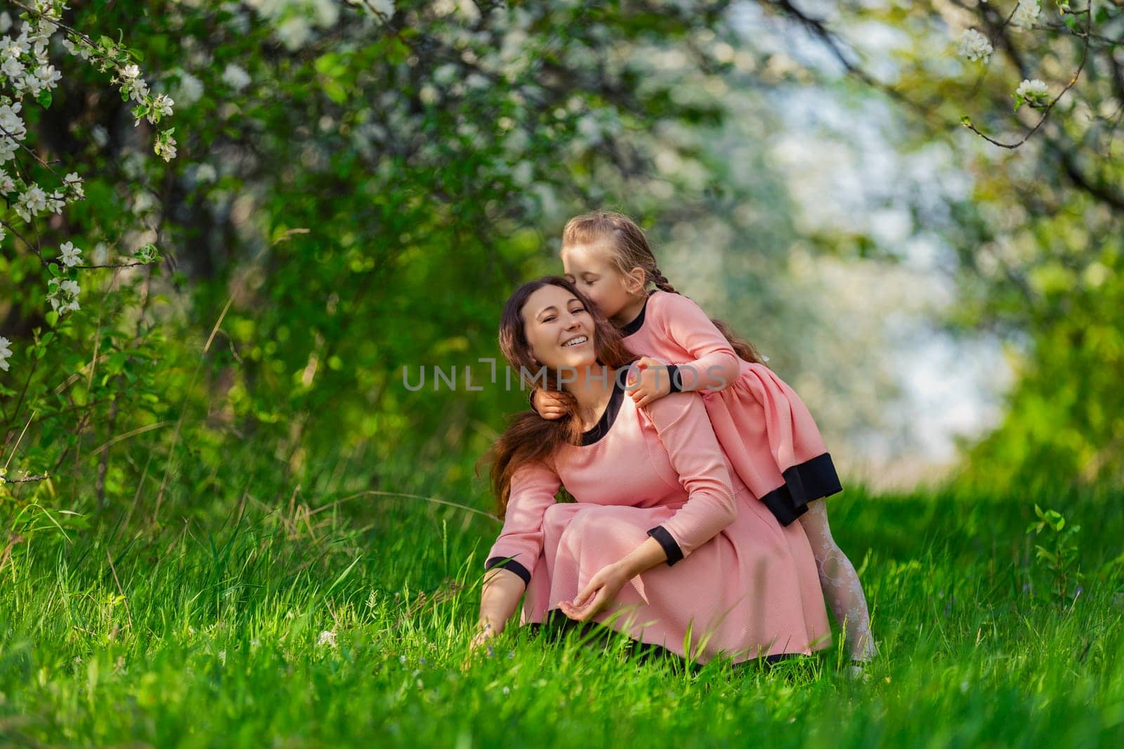 mother and daughter in nature in identical dresses