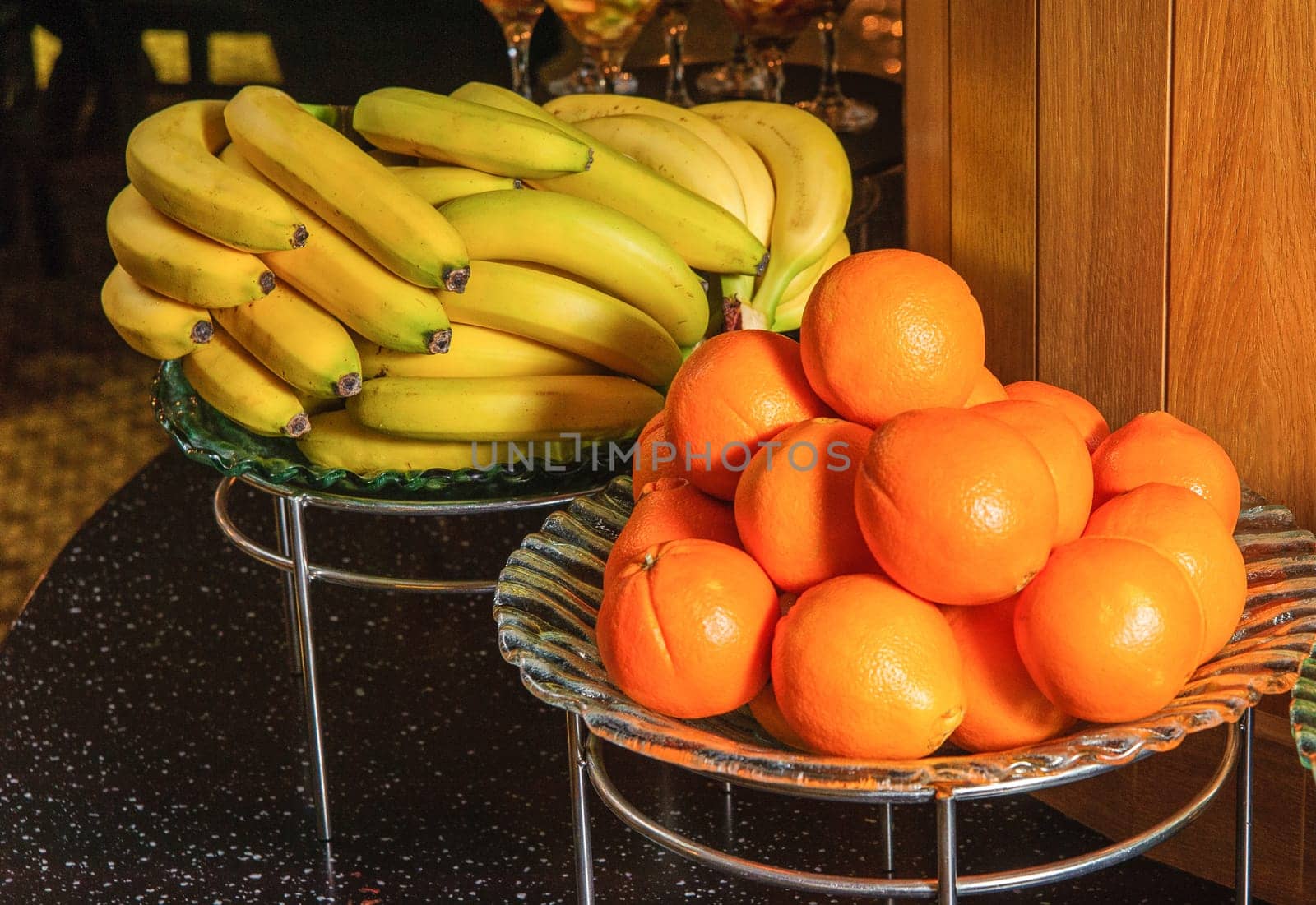 A buffet table with fruit bowls full of bananas and oranges