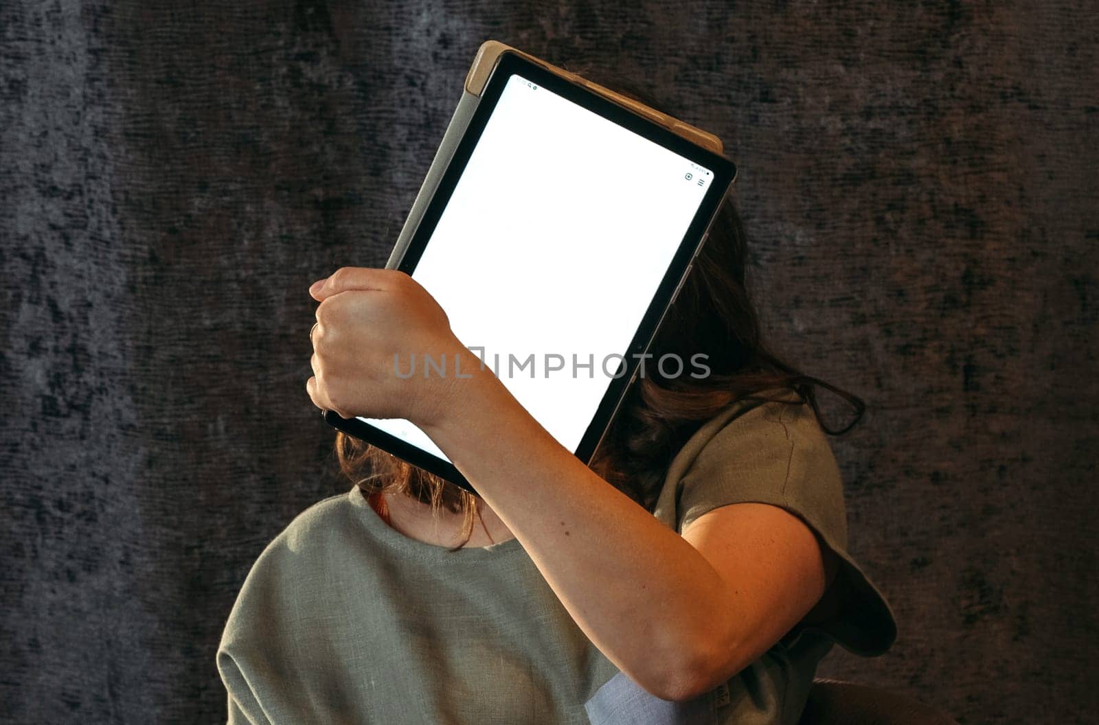 Portrait of a young woman who covers her face with a tablet. Mockup