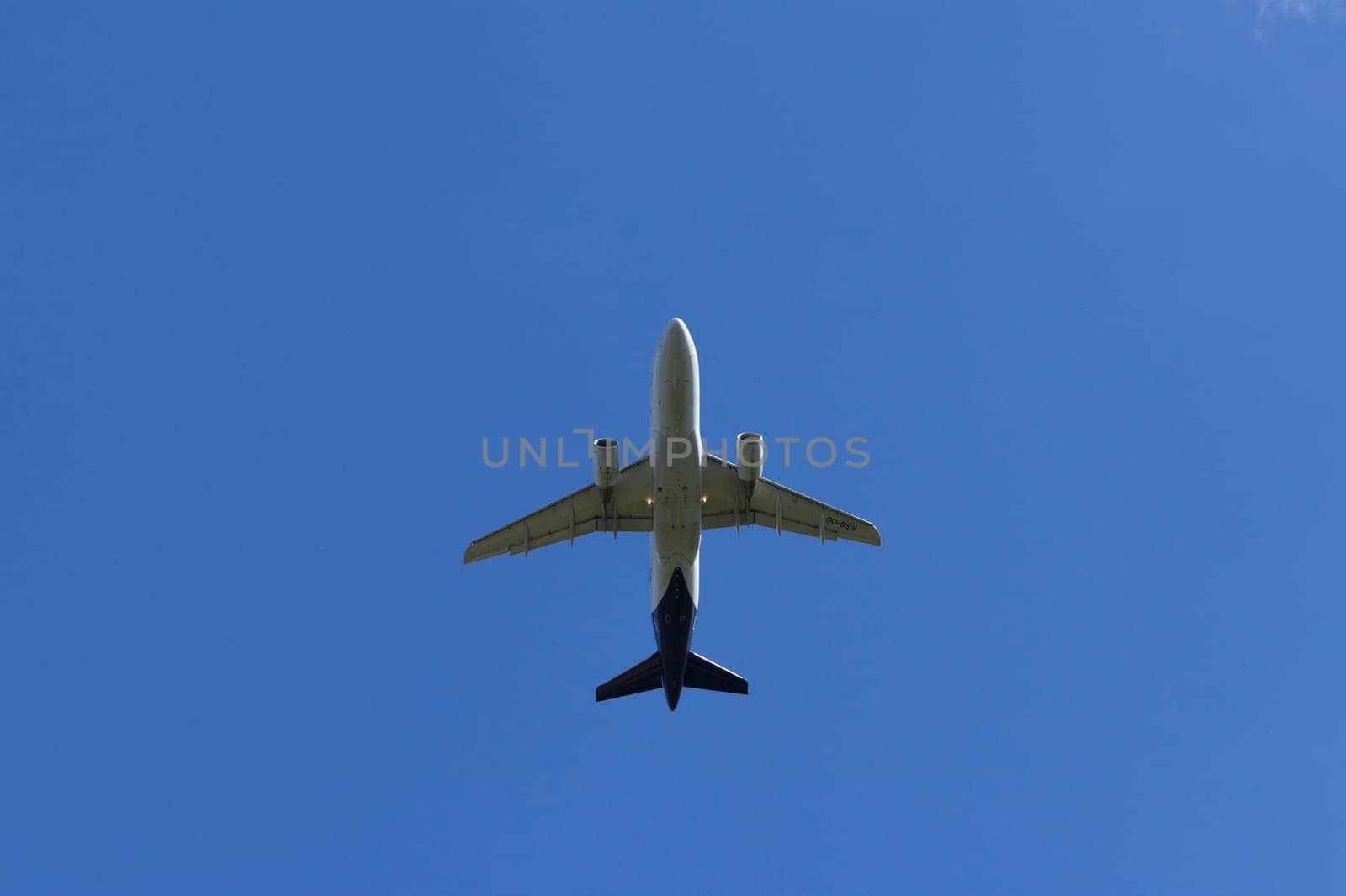 Airplane flies against a background of white clouds