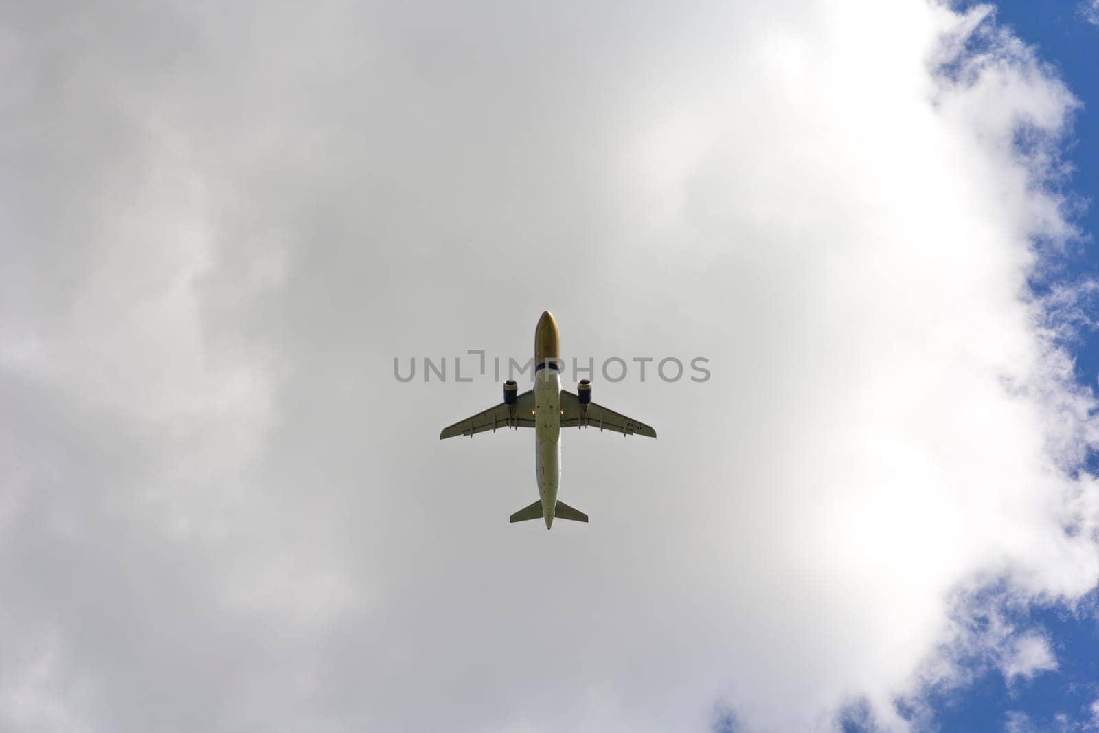 Airplane flies against a background of white clouds