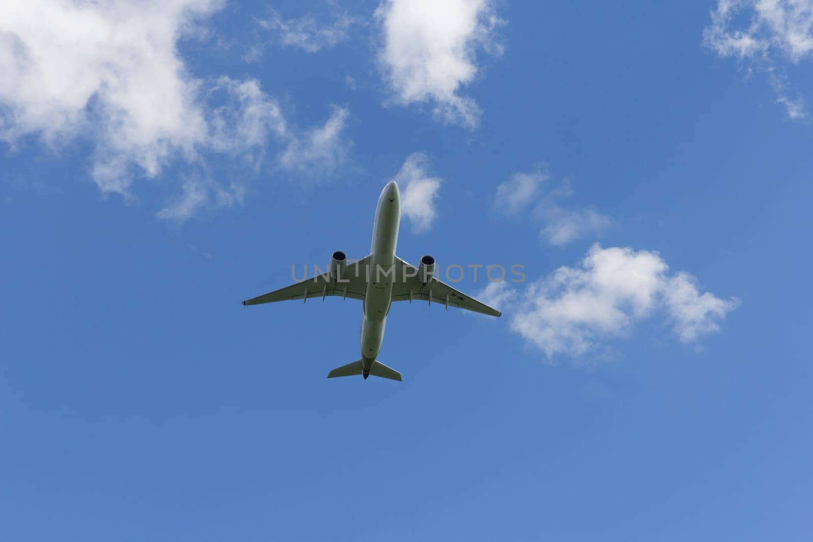 Airplane flies against a background of white clouds