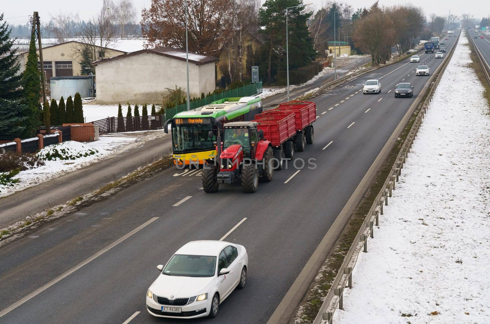 Poznan, Poland - January 24, 2023: Car traffic on a motorway in Poland. A bus and a tractor are driving in the foreground.