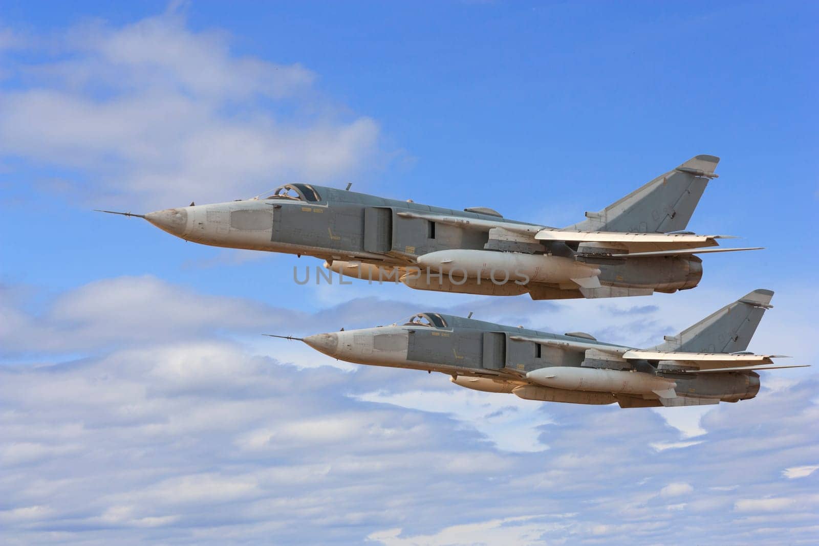 Military jet bomber Su-24 Fencer flying above the clouds.