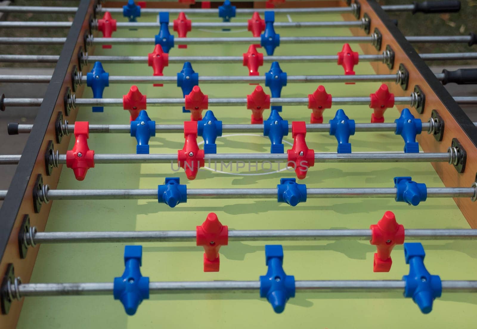 Table football in the entertainment center. Close-up image of plastic players in a football game.