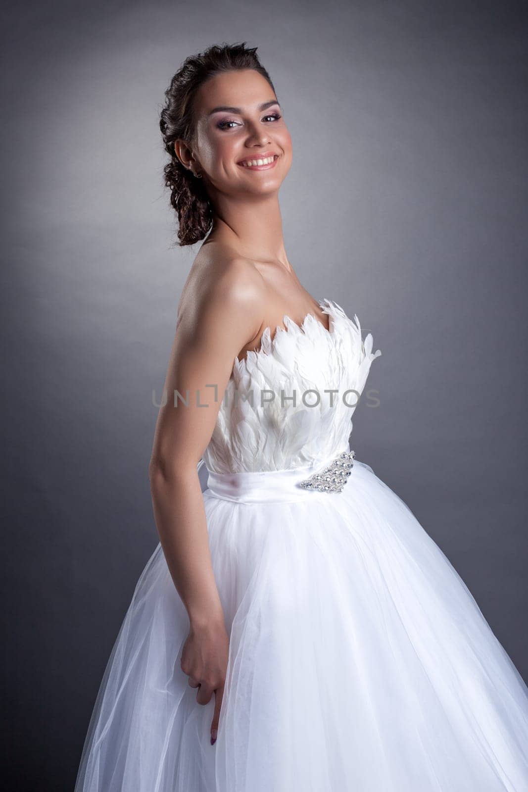 Portrait of happy young bride on gray background, close-up