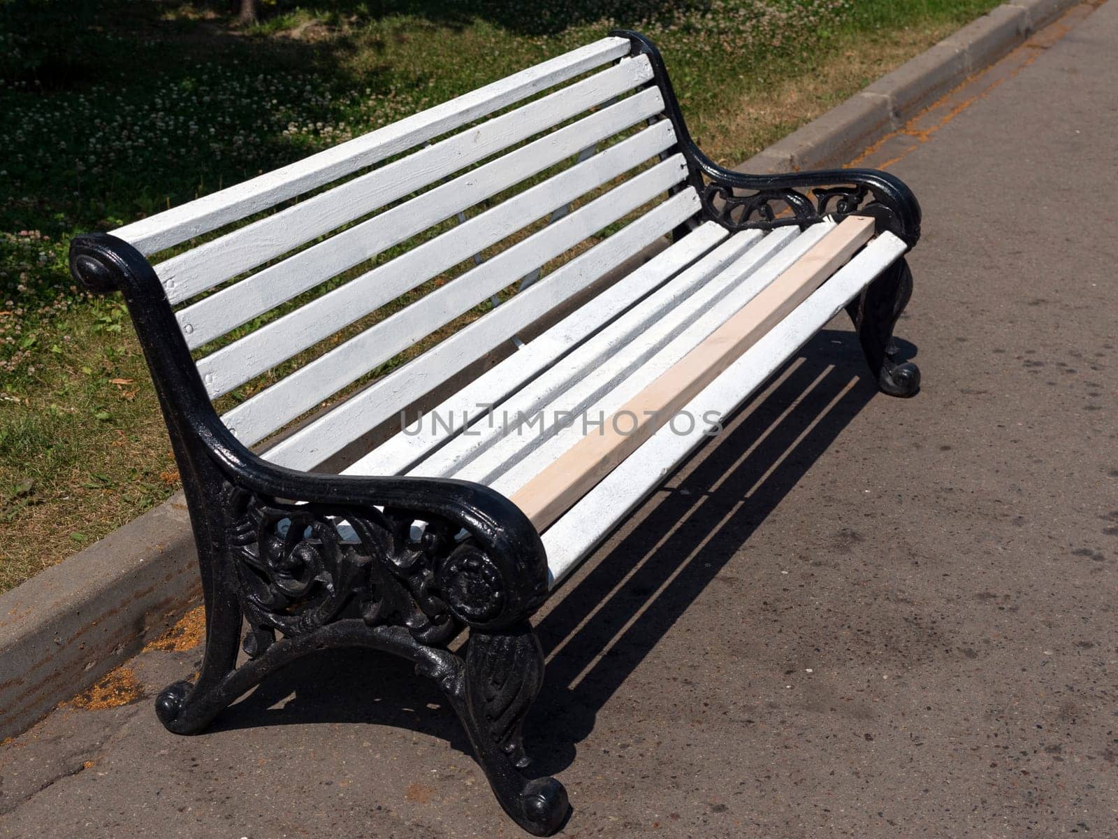 White wooden bench in the park on the street
