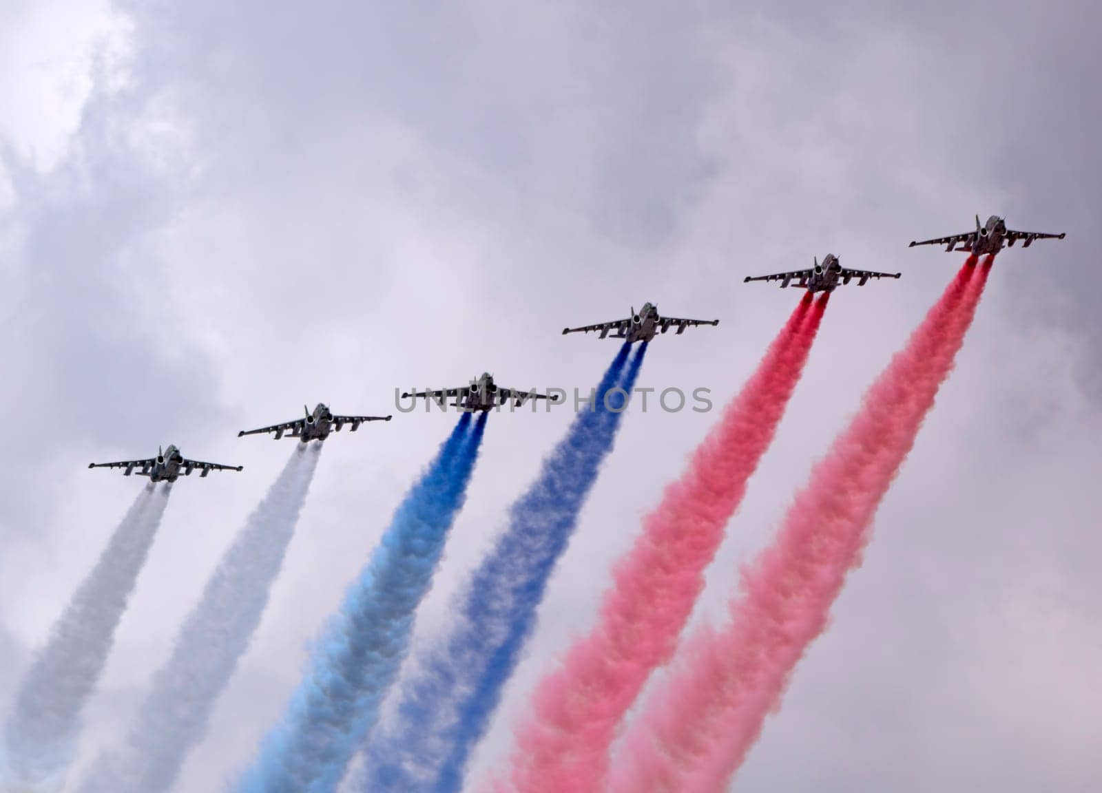 MOSCOW, RUSSIA - MAY 7, 2021: Avia parade in Moscow. Group of Russian fighters Sukhoi Su-25 with painted russian flag in the sky on parade of Victory in World War II in Moscow, Russia