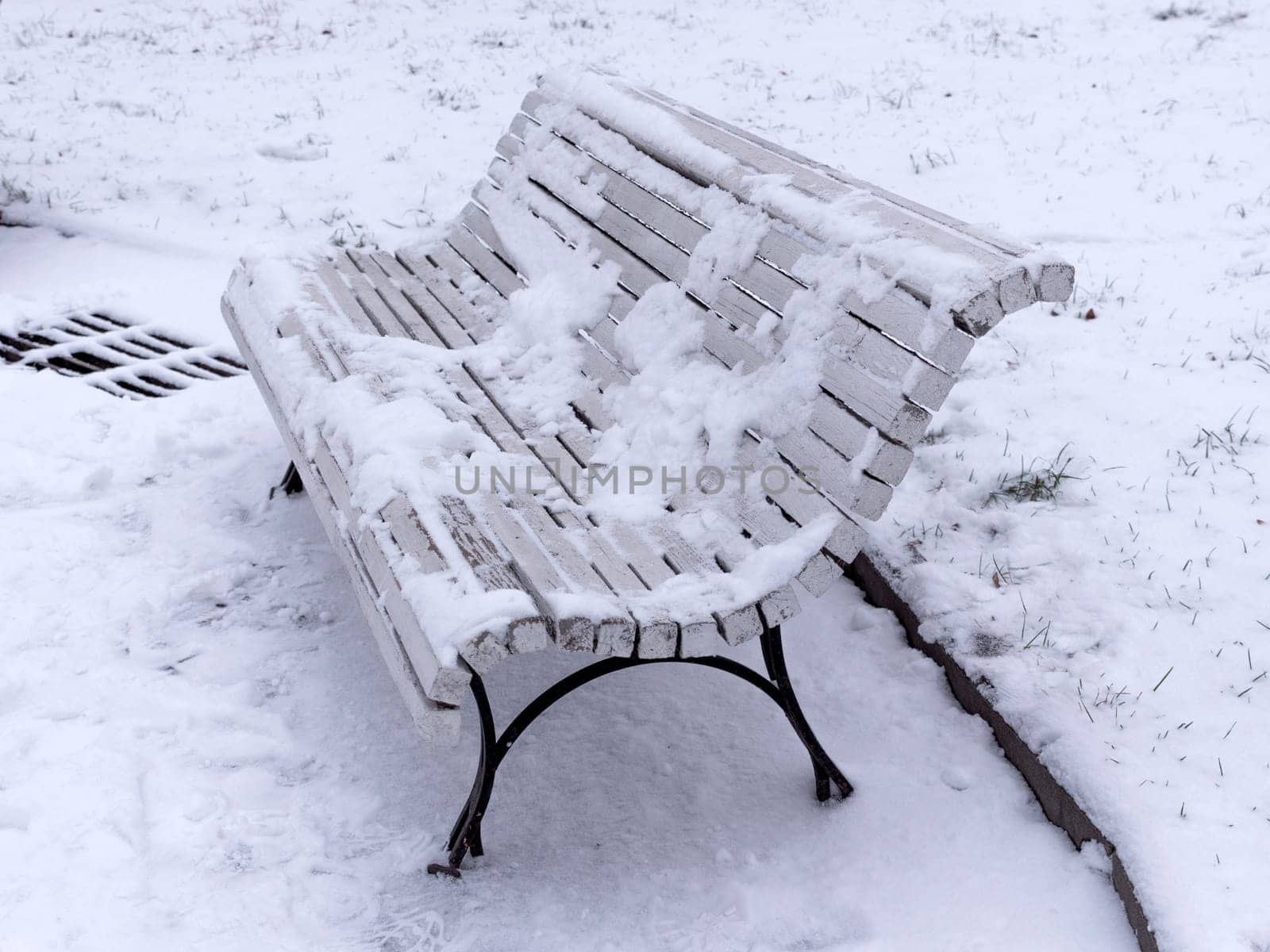 Bench in the park covered with snow.